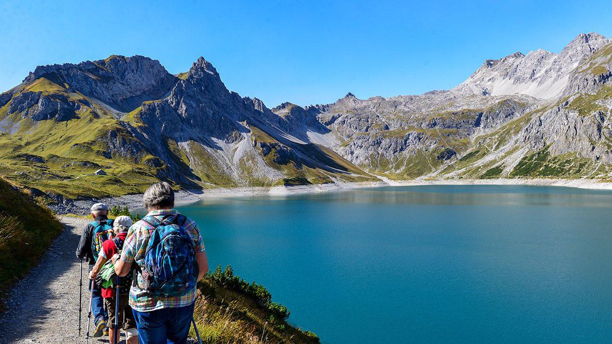 Wandergruppe auf Tour entlang eines Bergsees